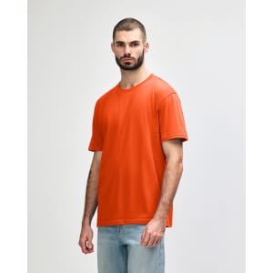 An orange Gildan Softstyle adult midweight T-shirt displayed on a model standing in a neutral stance.