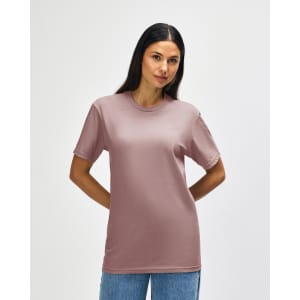 A model wearing a Gildan Softstyle Adult Midweight T-Shirt in a muted pink colour with navy blue sides.