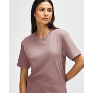 A midweight adult t-shirt in a soft rose hue, featuring a logo on the front.