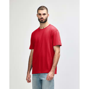 A red midweight t-shirt on a model, featuring a simple design and a logo on the shirt.