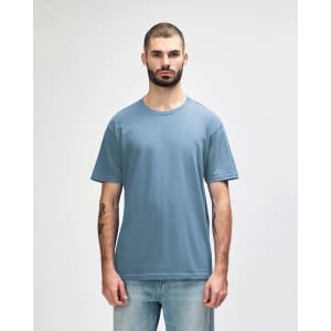A light blue midweight t-shirt worn by a male model, featuring a simple design and a logo.