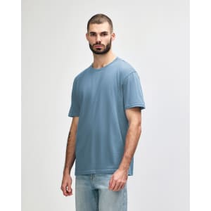 A light blue midweight t-shirt on a model, featuring a simple design and short sleeves. The shirt has a logo.