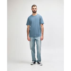 A light blue Gildan Softstyle adult midweight T-shirt displayed on a male model wearing light jeans.