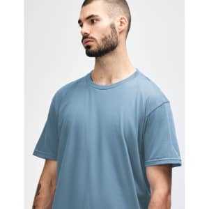 A light blue Gildan Softstyle adult midweight T-shirt featuring a crew neckline, displayed on a model.