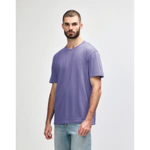 A purple Gildan Softstyle adult midweight T-shirt on a model, featuring a simple design and short sleeves.