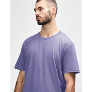 A purple Gildan Softstyle adult midweight T-shirt displayed on a model, featuring a logo on the chest.