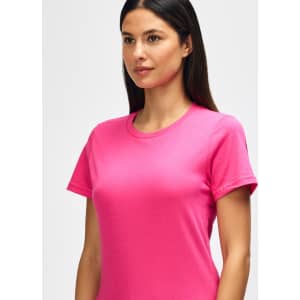 A model wearing a bright pink Gildan Softstyle ladies midweight t-shirt, showcasing a round neckline and short sleeves.