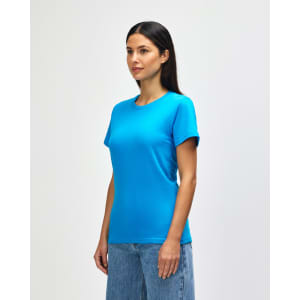 A bright turquoise ladies midweight t-shirt displayed on a model, paired with casual denim jeans.