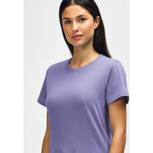 A model wears a light purple Gildan Softstyle ladies midweight T-shirt. The shirt has a round neckline and short sleeves.