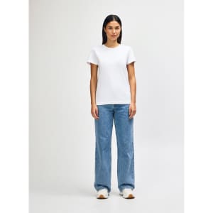 A model wearing a white ladies midweight T-shirt paired with blue jeans and white sneakers, standing in a neutral background.