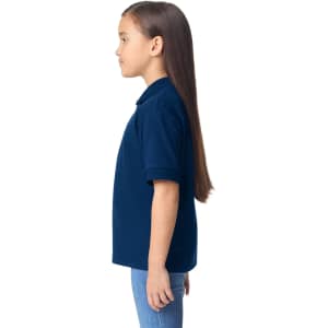 A navy blue youth polo shirt displayed on a girl with long hair, shown in profile. The shirt features a collar and short sleeves.