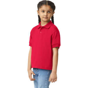 A red youth polo shirt with a collar and short sleeves, displayed on a child with braids. The shirt features a logo.
