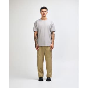 A grey American Apparel Super Heavyweight T-Shirt displayed on a model, paired with light blue jeans and sneakers.