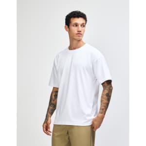 A white American Apparel Super Heavyweight T-Shirt displayed on a male model in a relaxed pose.