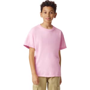 A pink youth short sleeve t-shirt displayed on a person, featuring a simple design and a logo.