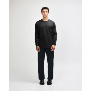 A black Super Heavyweight T-Shirt paired with loose blue jeans and black sneakers, displayed on a model.