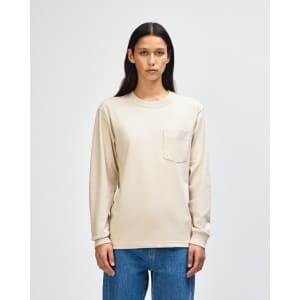 A lightweight, long-sleeve beige t-shirt featuring a pocket and a logo on the chest.