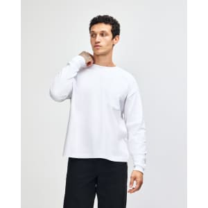 A model wearing a grey, long-sleeve American Apparel Super Heavyweight T-Shirt featuring a chest pocket.