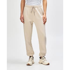 Unisex sweatpants in beige with an elastic waistband and cuffed ankles, paired with a light pink sweat top.