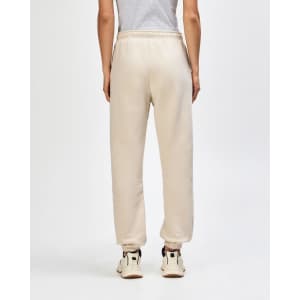 Unisex sweatpants in a beige colour with an elasticised waistband and cuffs, featuring a visible logo.