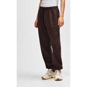Brown unisex sweatpants with a drawstring waist, featured alongside black sneakers. The pants have a logo.