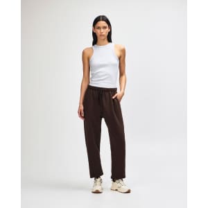 Unisex sweatpants in brown with an elastic waistband; styled with a matching brown hoodie. Features a branding logo.