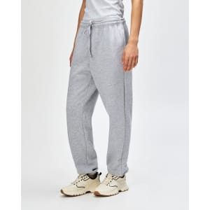 Grey unisex sweatpants made of fleece, featuring a drawstring waist and side pockets. Styled with sneakers.