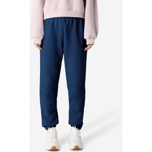 Unisex sweatpants in navy blue, featuring an elastic waistband and cuffs, paired with a light pink top and white shoes.