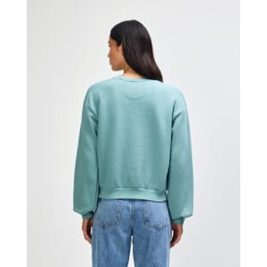 A women's crewneck sweatshirt in teal, featuring a relaxed fit and ribbed cuffs, with a logo on the back.