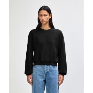 A black women's crewneck sweatshirt with long sleeves and a relaxed fit, featuring a simple design.