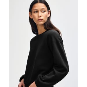 A black women's crewneck sweatshirt with long sleeves, featuring a simple design and a branded logo.