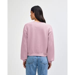 A women's crewneck sweatshirt in soft pink, featuring a relaxed fit and a branded label on the back.