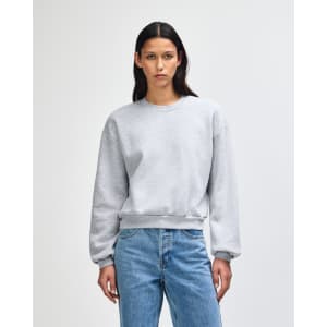 A grey women's crewneck sweatshirt with a relaxed fit and long sleeves, featuring a small logo.