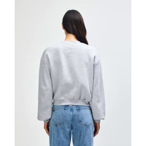 A women's crewneck sweatshirt in grey, featuring a relaxed fit and long sleeves, visible from the back.
