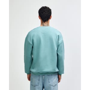 A unisex crewneck sweatshirt in a muted green colour, featuring a simple design and loose fit. It has a logo.