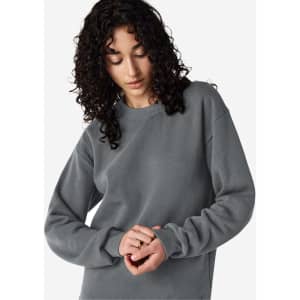 A unisex crewneck sweatshirt in grey featuring long sleeves and a relaxed fit, with a small logo on it.