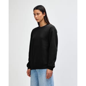 A black unisex crewneck sweatshirt with a relaxed fit and ribbed cuffs. It features a branding logo.