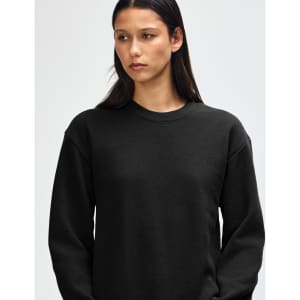 A black unisex crewneck sweatshirt with long sleeves, featuring a logo on the front.