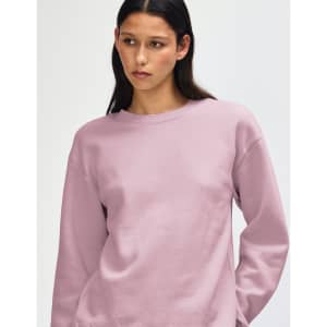 A unisex crewneck sweatshirt in a soft pink hue, featuring a casual design and a logo on the sleeve.