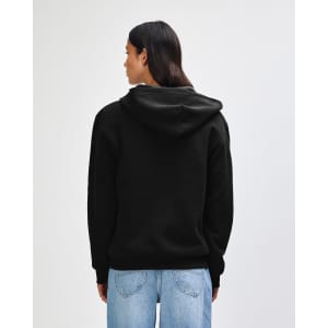 A model wearing a black unisex full zip hooded sweatshirt paired with light blue baggy jeans and black sneakers.