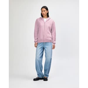 A unisex full zip hooded sweatshirt in soft pink, featuring a relaxed fit and a front zip. It has a logo.