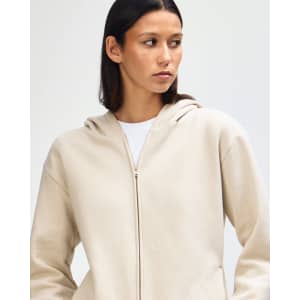 A unisex full zip hooded sweatshirt in a light cream colour, featuring a hood and front zipper.