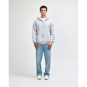 A unisex full zip hooded sweatshirt in grey, worn with blue jeans and white sneakers, featuring a logo.