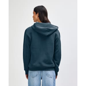 A navy blue unisex full zip hooded sweatshirt, featuring a hood and a logo. The model has curly hair and faces away.