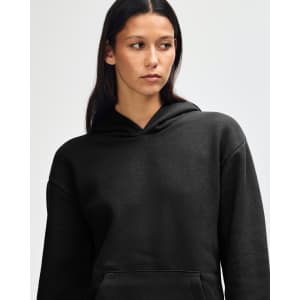 A black unisex hooded sweatshirt with a front pocket and a relaxed fit. It features a logo on the garment.