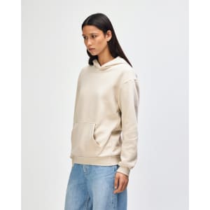 A unisex hooded sweatshirt in beige featuring a front pocket and a logo on the chest.