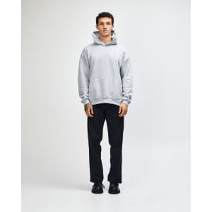 A unisex grey hooded sweatshirt with a kangaroo pocket, paired with light blue jeans and black sneakers.