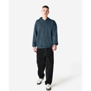 A unisex hooded sweatshirt in dark grey, featuring a front pocket and an attached hood, paired with cargo pants.