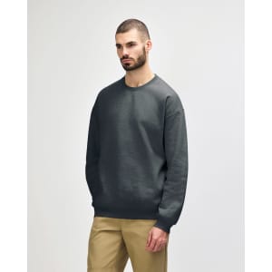 A dark green Gildan Softstyle adult sweatshirt on a model, featuring a casual design and long sleeves.