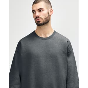 An olive green Gildan Softstyle adult sweatshirt displayed on a male model, featuring a simple design and crew neck.